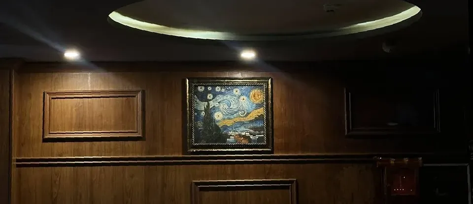 나무 벽면 인테리어와 고흐의 명화 액자 장식