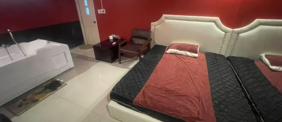 더블 침대와 흰색 자쿠지가 있는 방