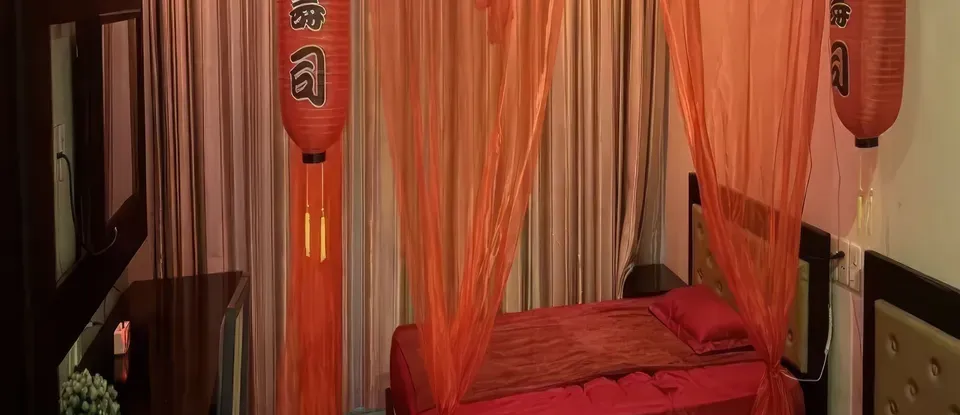 붉은 침구와 주황색 등이 있는 침실