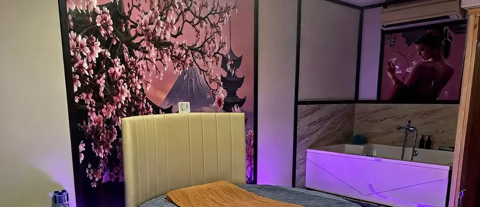 둥근 침대와 보라색 조명의 욕조