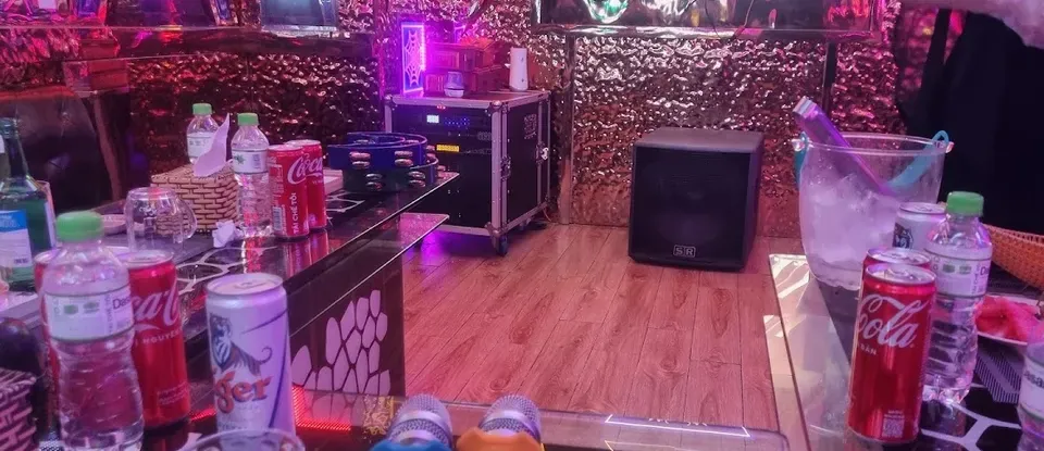 테이블 위 음료와 마이크가 세팅된 룸 내부