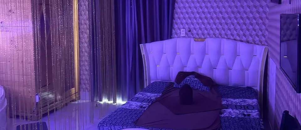 파란색 조명과 흰색 침대가 있는 방